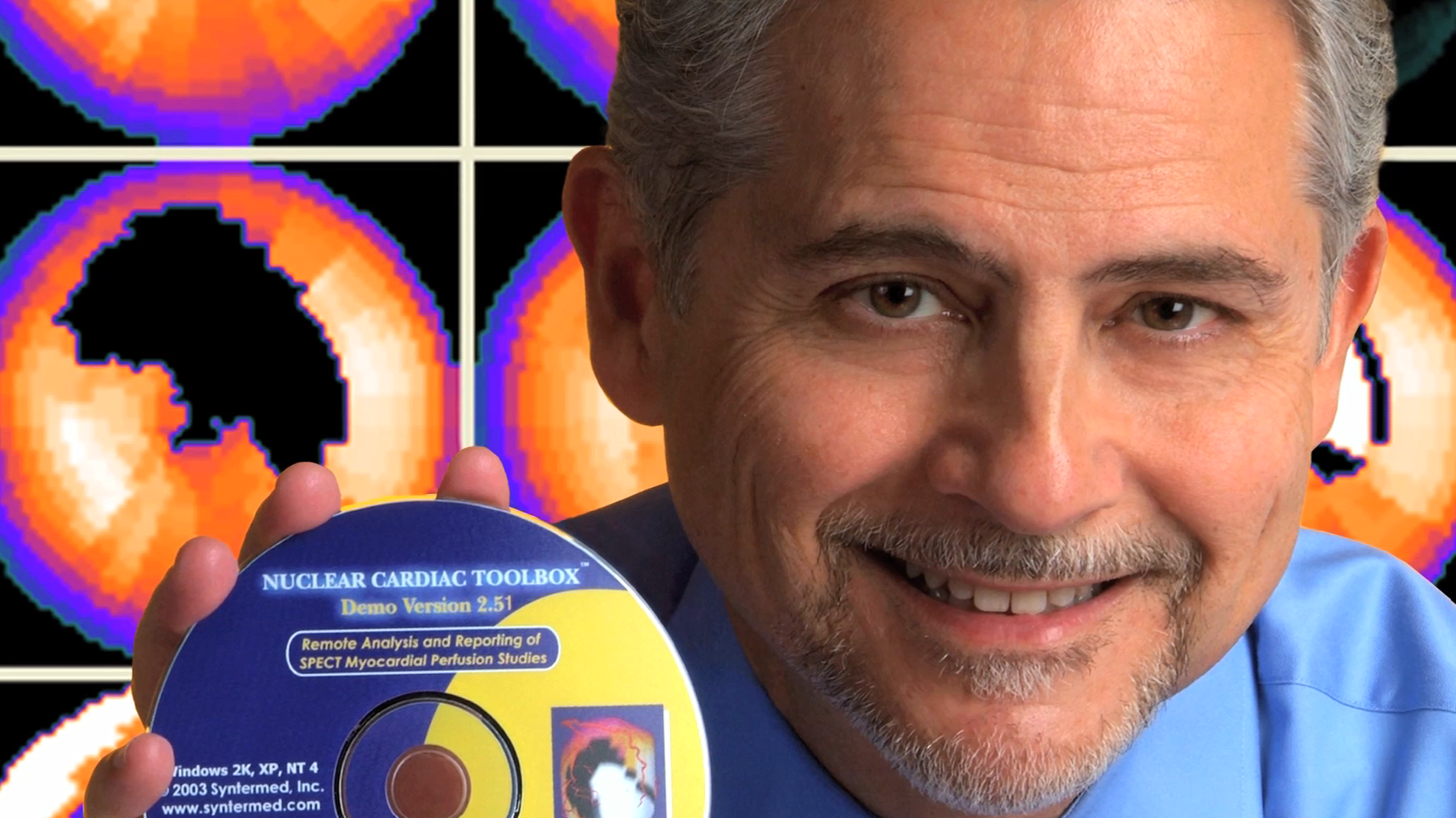 Photo of Ernest Garcia holding a CD called "Nuclear Cardiac Toolbox" with cardiac imaging behind him
