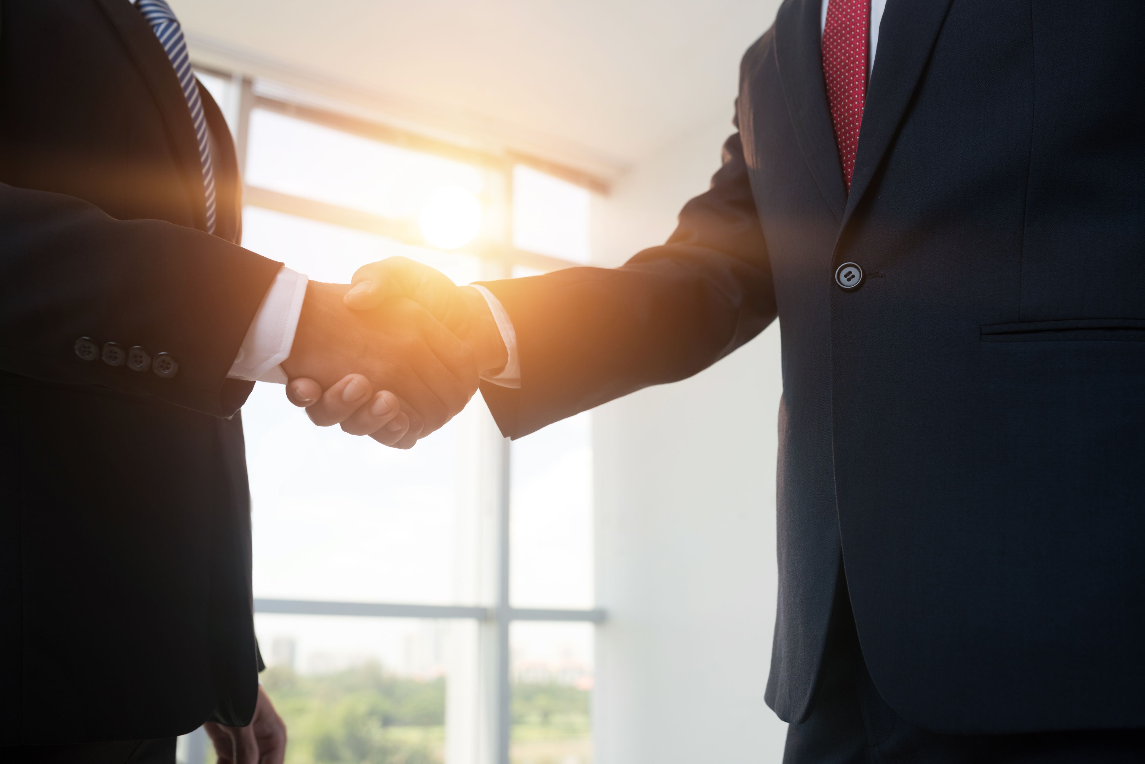 Two people in business suits shake hands
